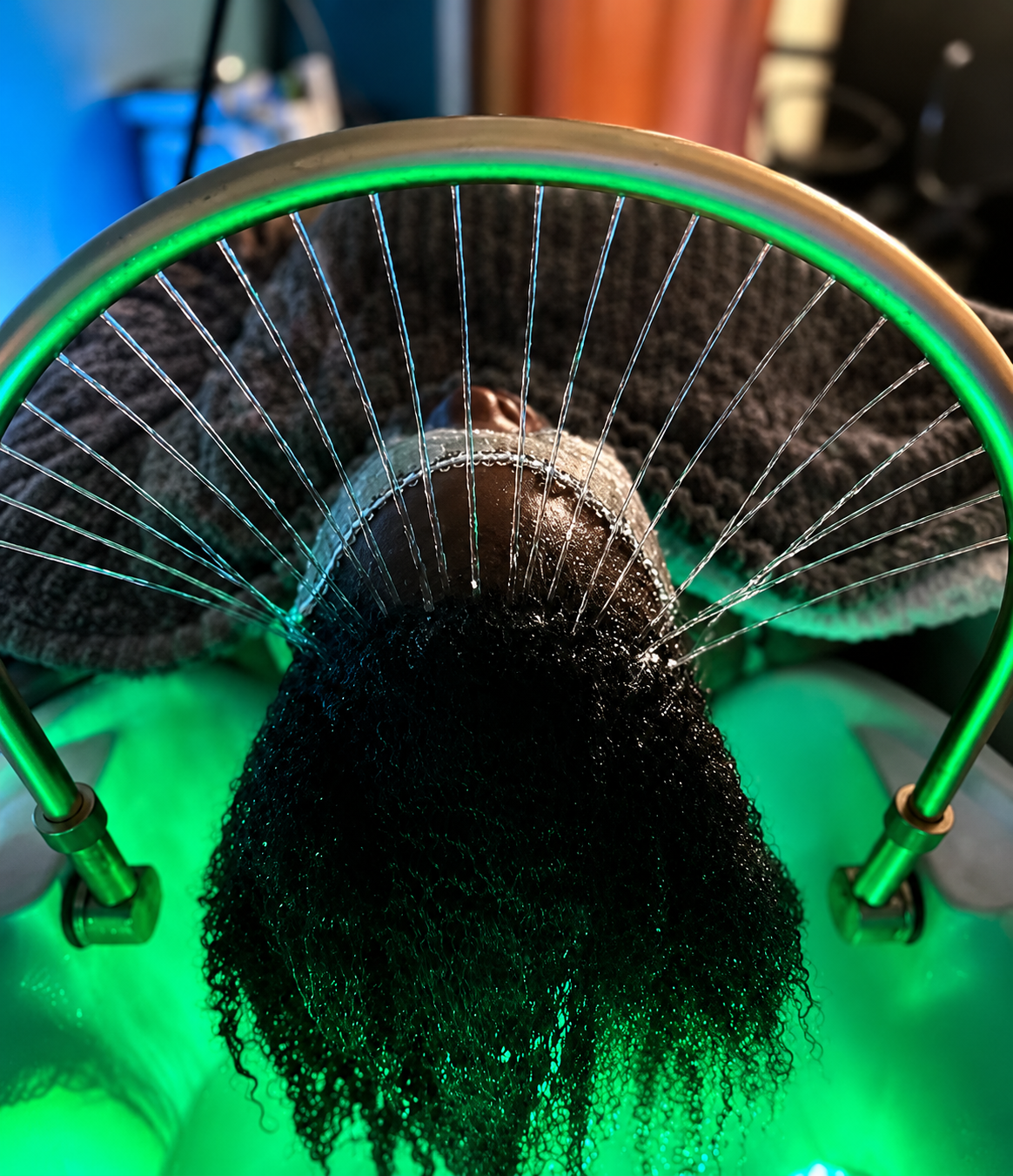 Cascading water therapy under a glowing green LED halo