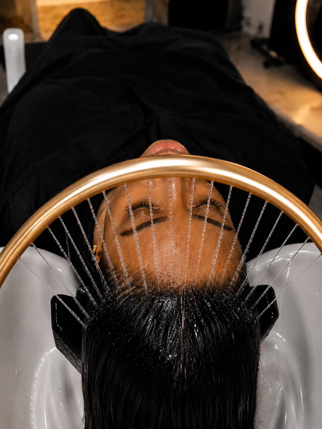 Golden halo hydro rinse cascading over the scalp
